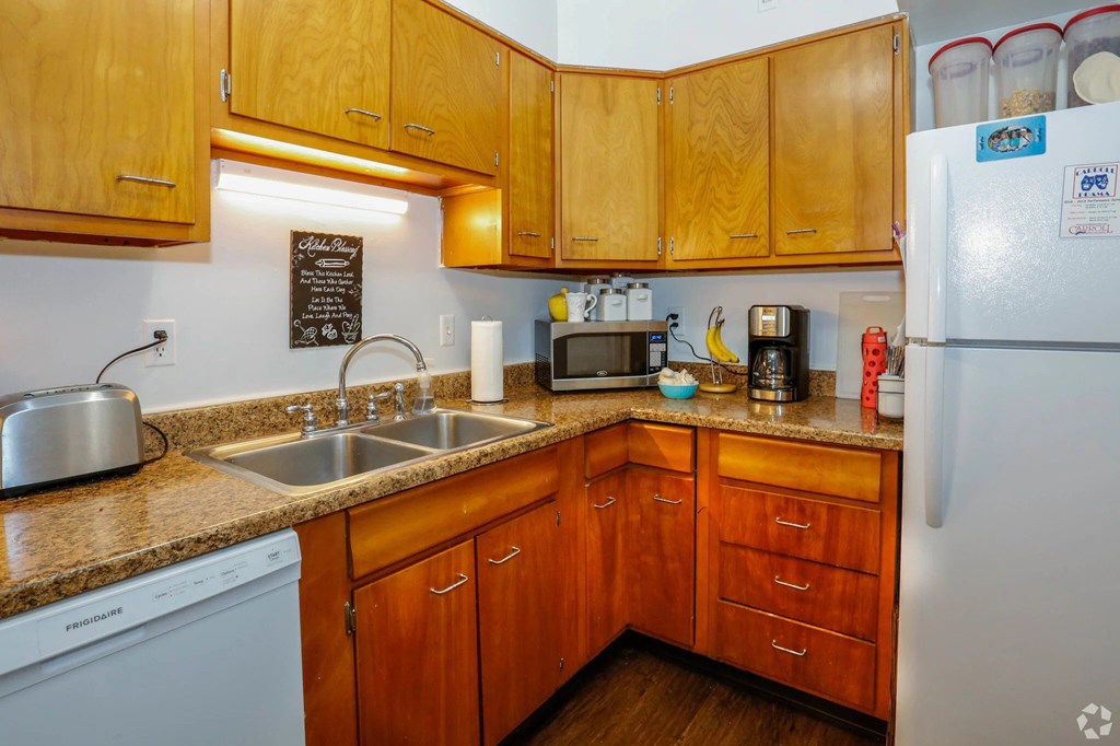 A kitchen with wooden cabinets and a white fridge.