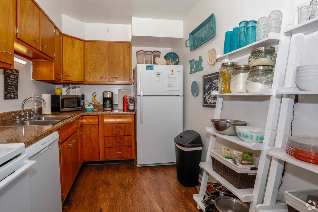 A kitchen with a white fridge and wooden cabinets.