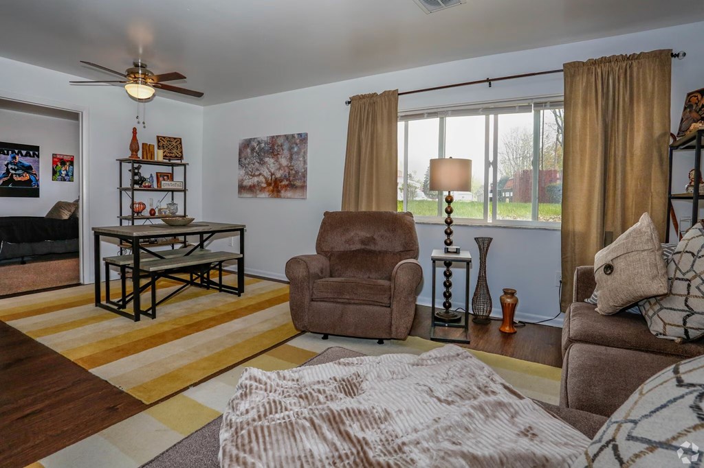 A living room with a brown chair and a brown couch.