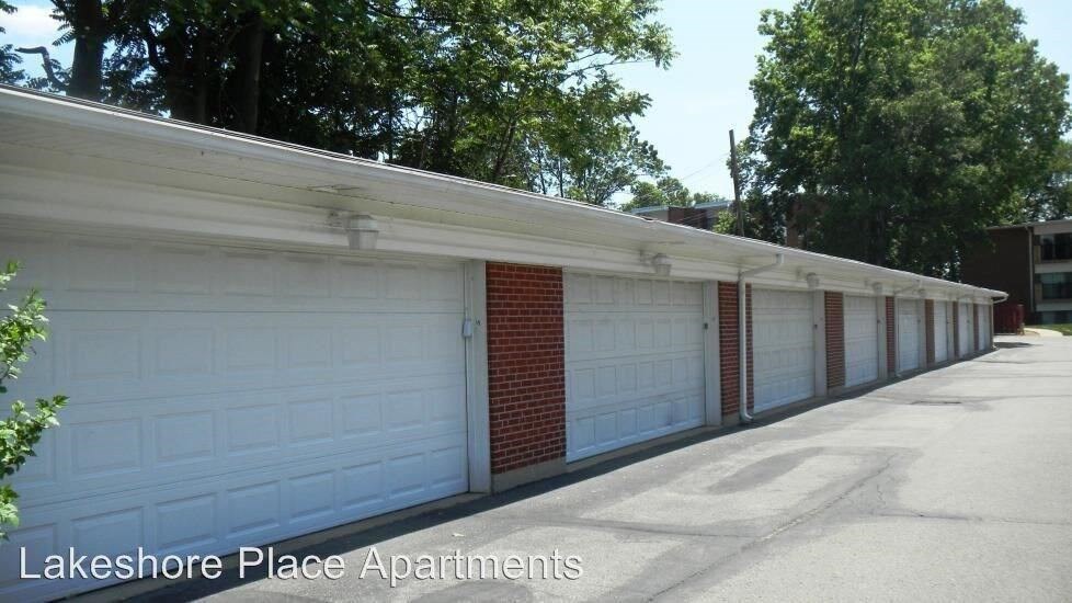 A row of garage doors in front of a building with the text Lakeshore Place Apartments.