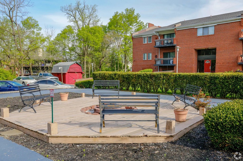 A red building with a balcony and a fire hydrant in front of it.