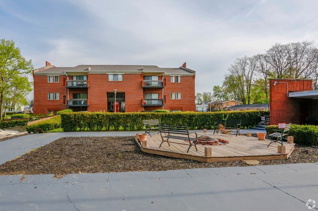 A red brick building with a patio and a fire pit in front.