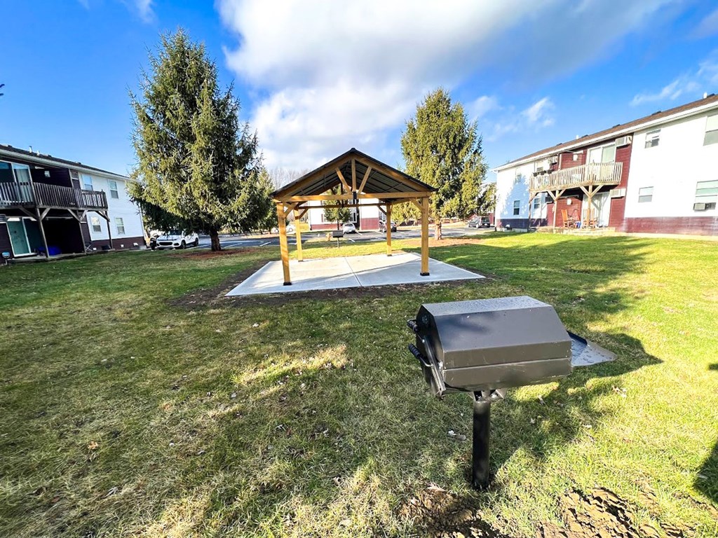 a picnic table with a pavilion in the background and a grill in the foreground at Ridgeview, Indiana, 46040