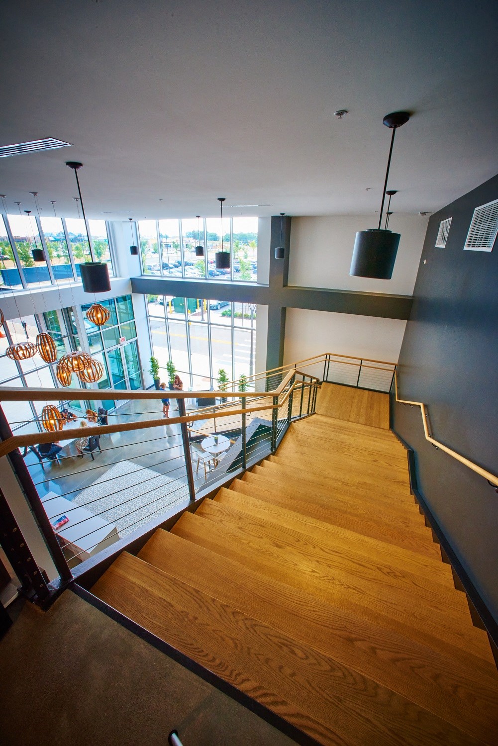 a view down the stairs of a building with a view of a lobby and windows