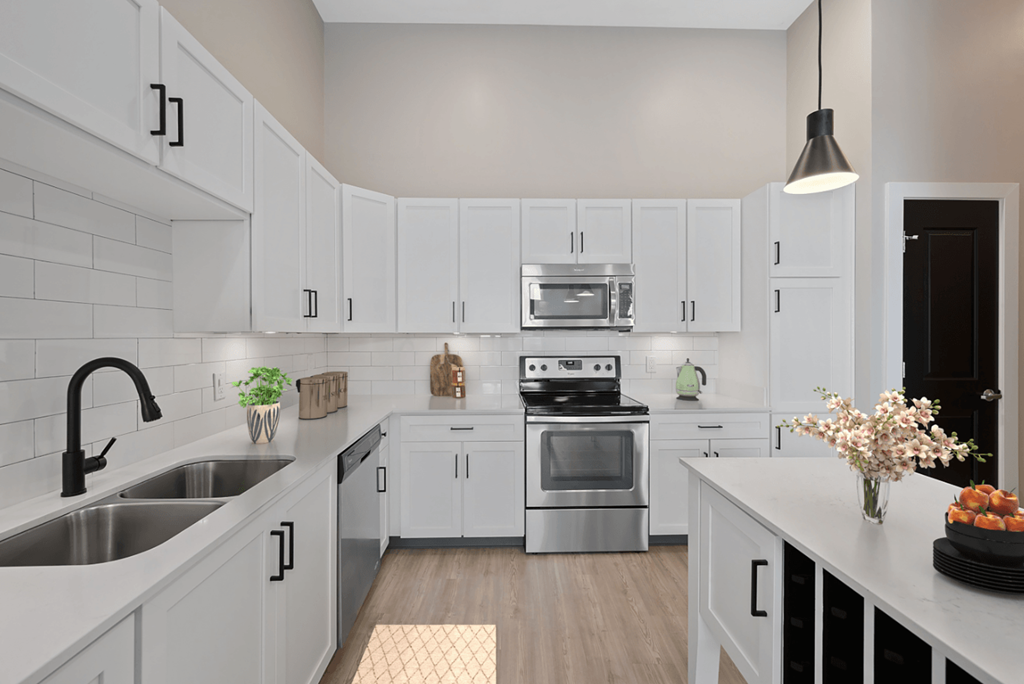 a large white kitchen with stainless steel appliances and white cabinets