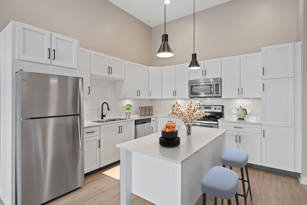 a large white kitchen with stainless steel appliances and a white island