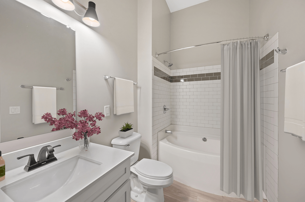 a white bathroom with a shower and a toilet and a sink