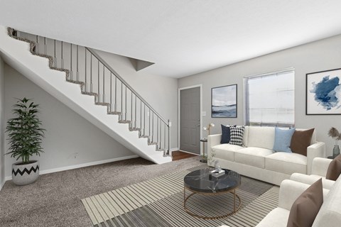 A living room with a staircase and a couch.