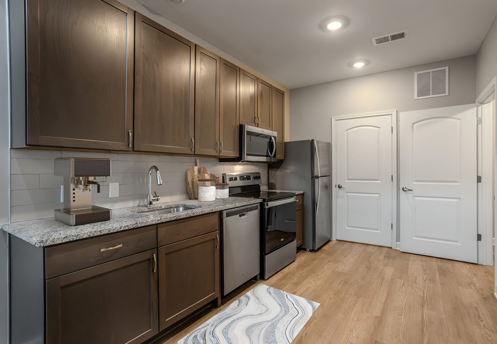 a kitchen with stainless steel appliances and wooden cabinets at Adelphi Quarter, Columbus, OH