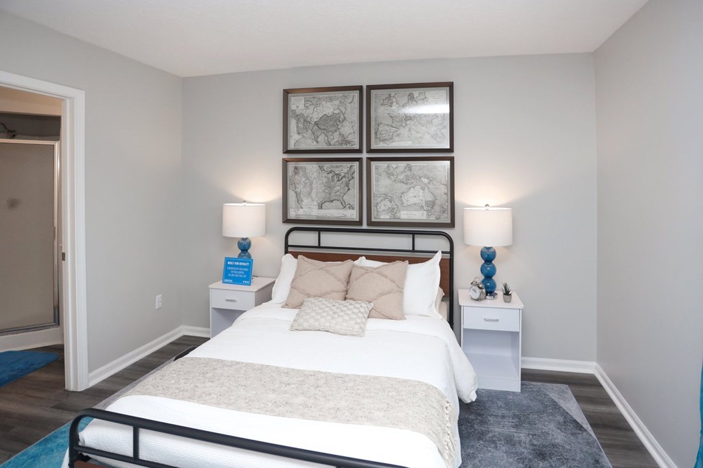 A bedroom with a large bed and a white nightstand.