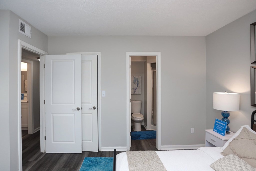 A bedroom with a bed, nightstand, and a lamp.