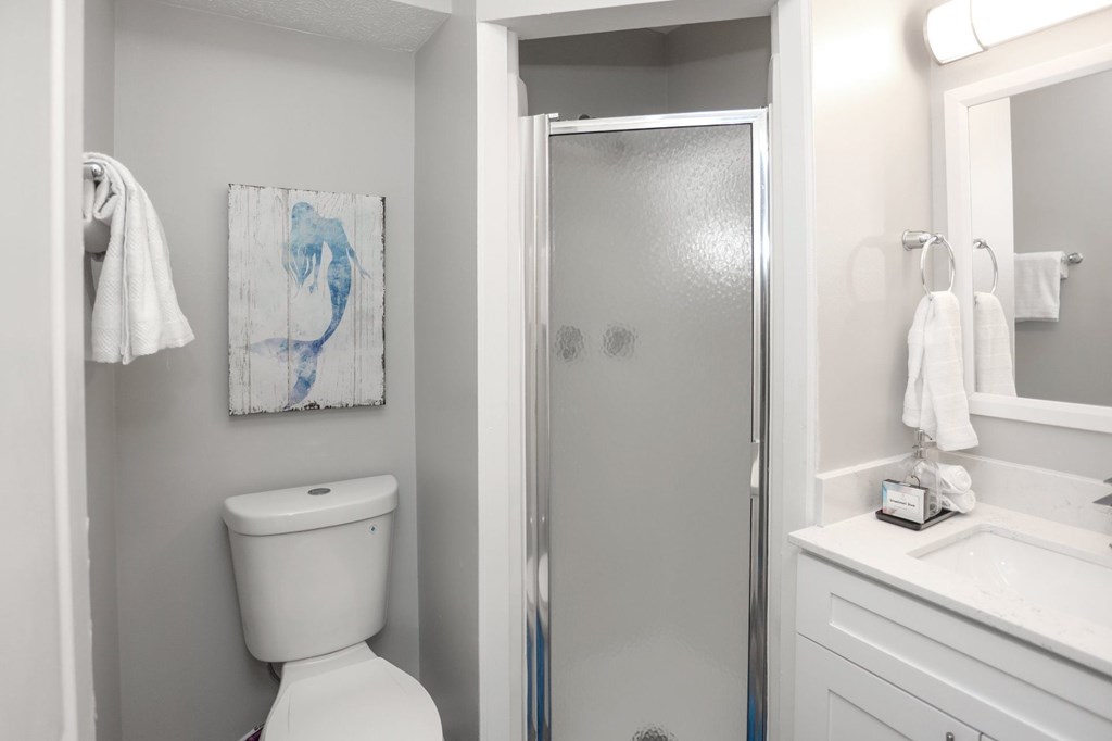 A white toilet sits next to a white sink in a bathroom.