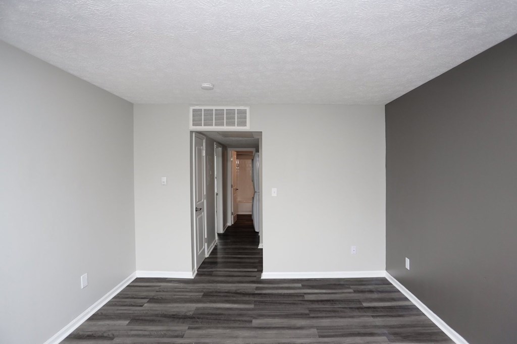 A room with a white ceiling and a doorway leading to another room.