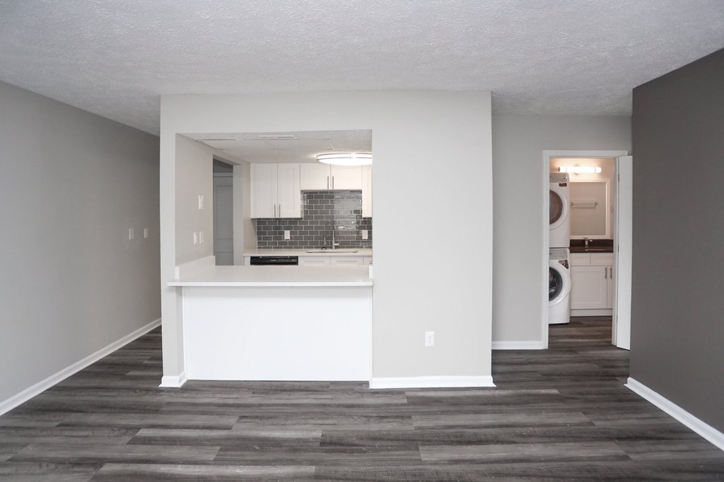 A kitchen with a white counter and a small island in the middle.