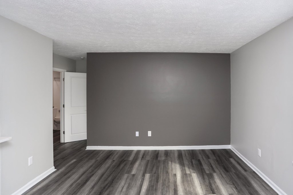 A room with a wooden floor and a white door.