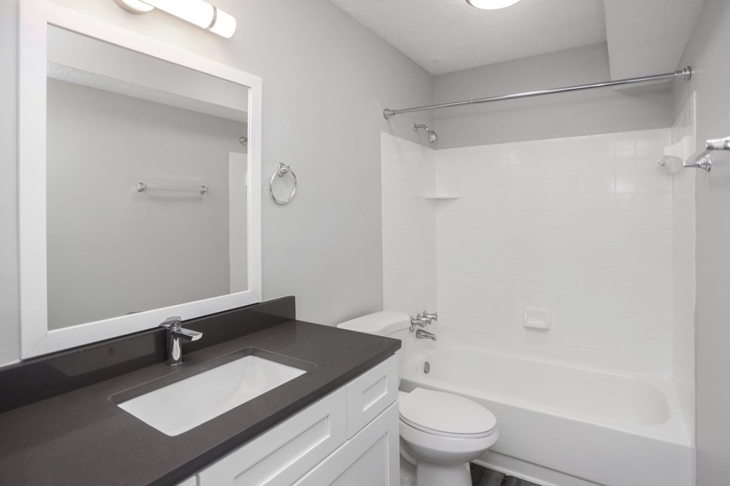A bathroom with a sink, toilet, and bathtub.