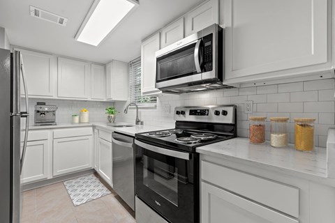 Kitchen with white cabinets and black appliances and a microwave at Merrick Place, Lexington, KY, 40502