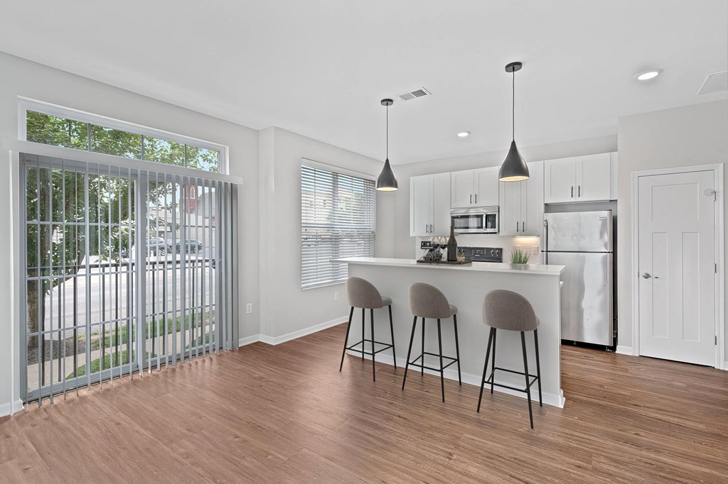 a kitchen with a bar and a sliding glass door at Monmouth Row Apartments, Newport, KY