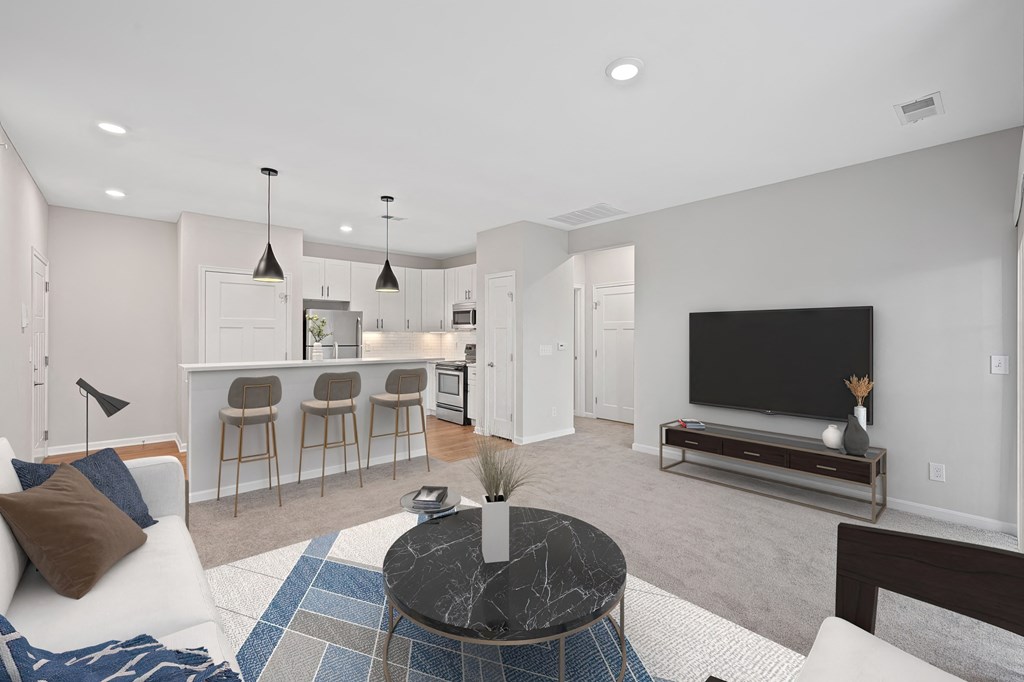 a living room with a couch and a coffee table and a kitchen at Monmouth Row Apartments, Newport, KY