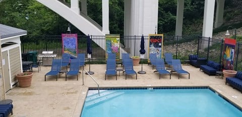 the pool and chairs at the poolside of a house