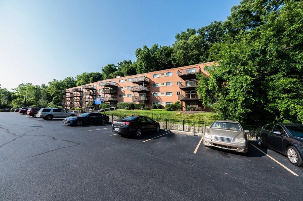 a parking lot with cars in front of an apartment building