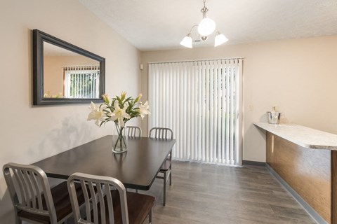a dining room with a table and chairs and a window at Parkside at Maple Canyon Apartments, Columbus, OH
