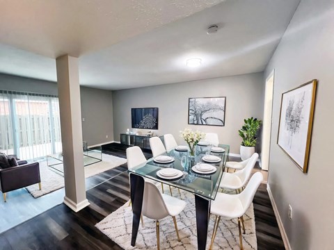 A dining room with a glass table and white chairs at A62 Apartments, Indianapolis, IN 46220