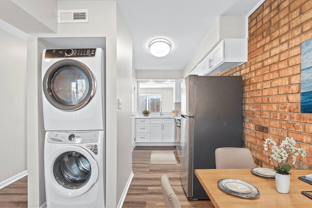 A modern laundry room with a washer and dryer stacked on top of each other at Fountain Parc Apartments, Indiana