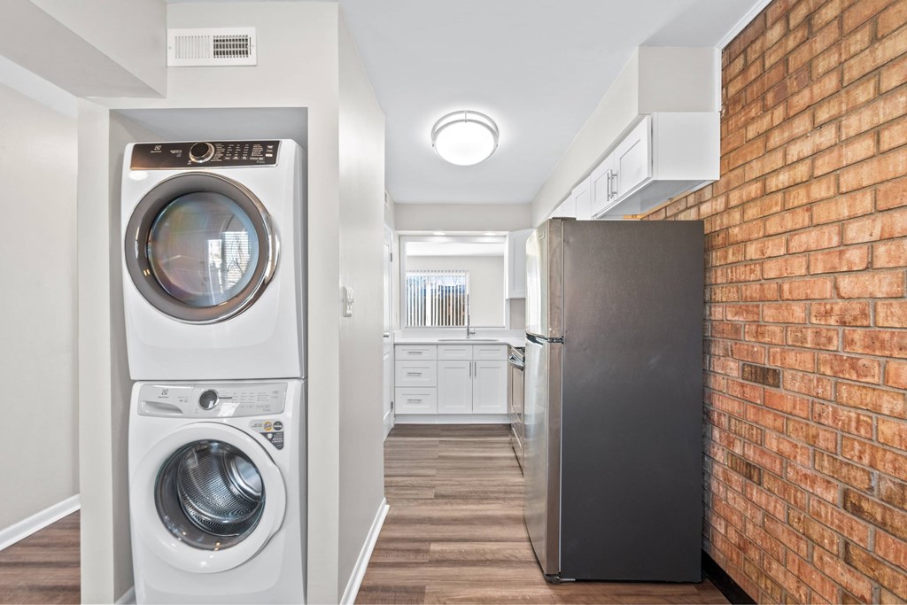 A black refrigerator is in a kitchen next to a brick wall at Fountain Parc Apartments, Indiana 46220
