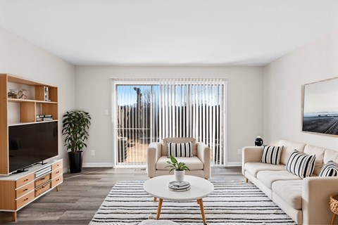 A living room with a white couch, a coffee table, and a television at Fountain Parc Apartments, Indianapolis