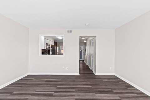 A long, empty hallway with a kitchen visible through the doorway at Fountain Parc Apartments, Indianapolis