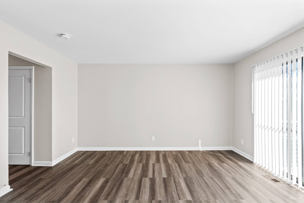 A room with wooden flooring and white walls at Fountain Parc Apartments, Indiana 46220