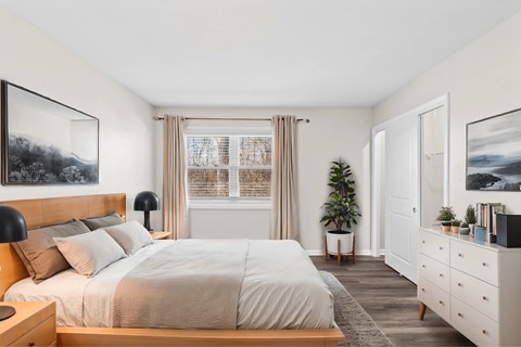 A bedroom with a large bed, a nightstand, and a dresser at Fountain Parc Apartments, Indianapolis, IN
