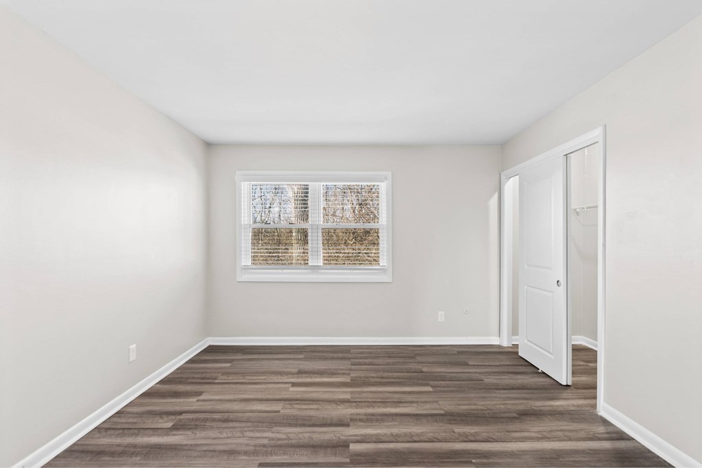 A room with a wooden floor and a window with blinds at Fountain Parc Apartments, Indianapolis, 46220