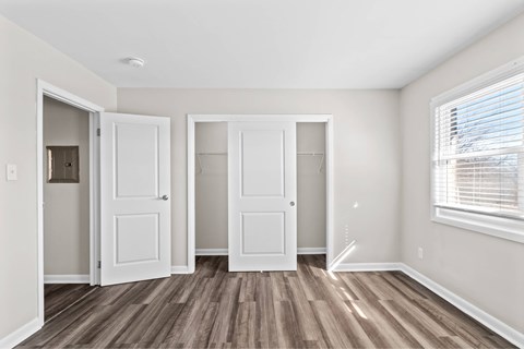 Three white doors are in a room with wood floors at Fountain Parc Apartments, Indianapolis