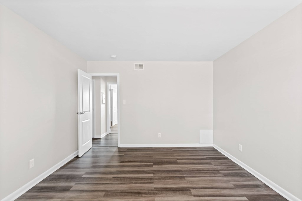 A long, empty hallway with a wooden floor and white walls at Fountain Parc Apartments, Indiana