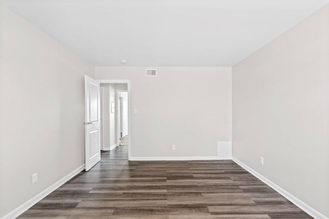 A long, empty hallway with a wooden floor and white walls at Fountain Parc Apartments, Indiana