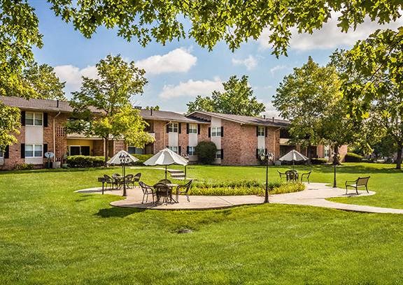 A sunny day at a residential area with houses, green lawns, and a picnic area at Fountain Parc Apartments, Indianapolis, IN 46220