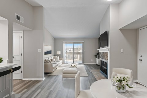 A living room with a white couch and a television on the wall.