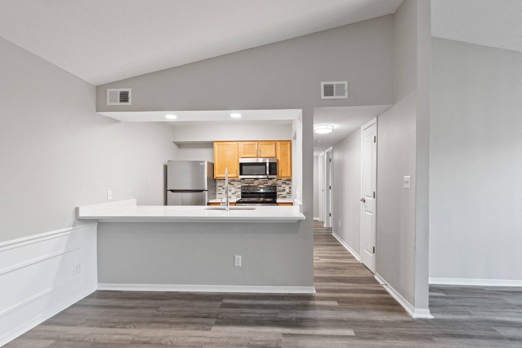 A kitchen with a white countertop and a wooden cabinet.