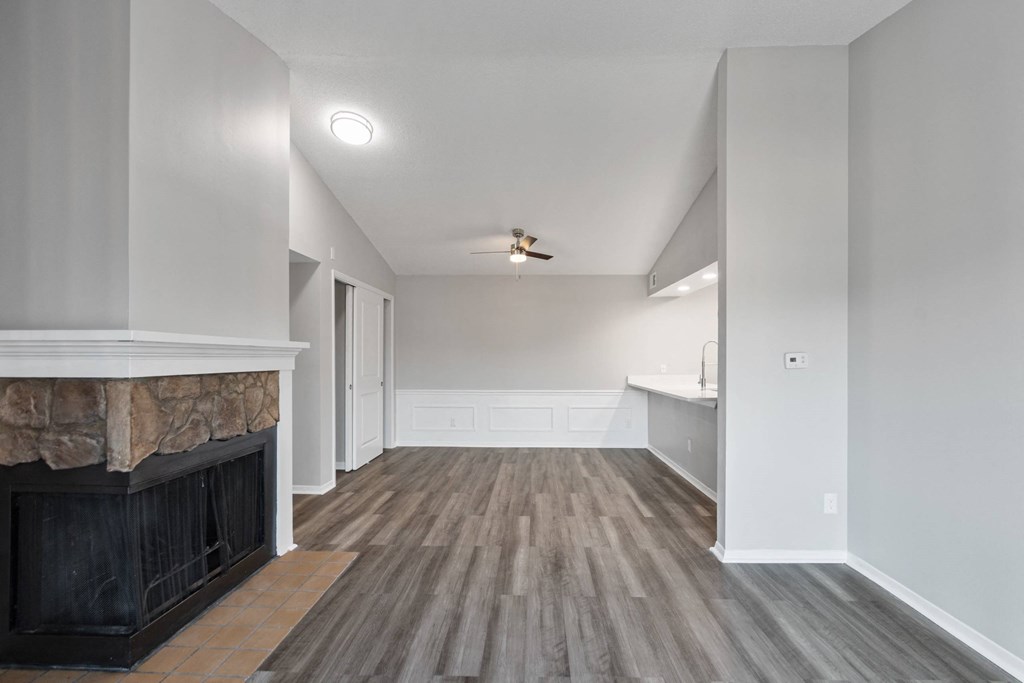 A room with a fireplace and wood flooring.
