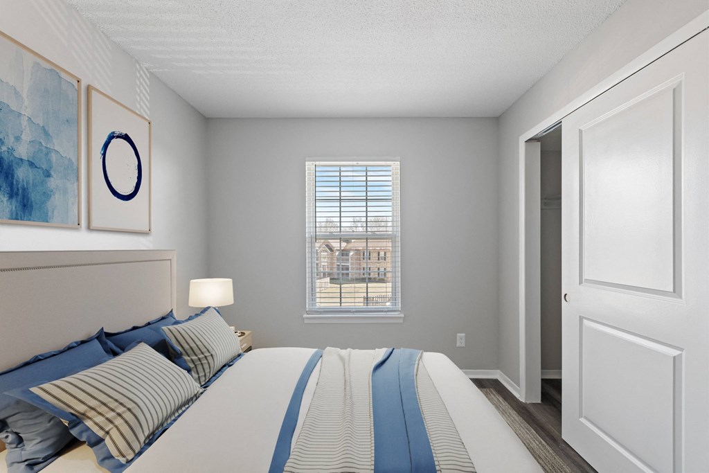 A bedroom with a large bed and a window overlooking a building.