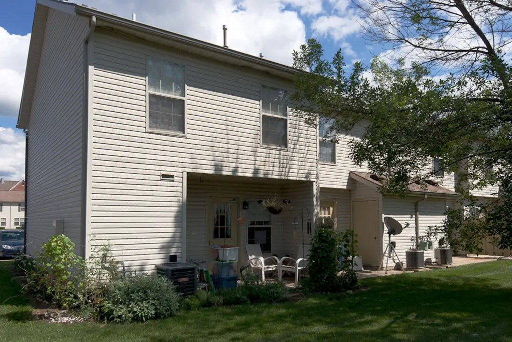 A house with a white siding and a covered patio.