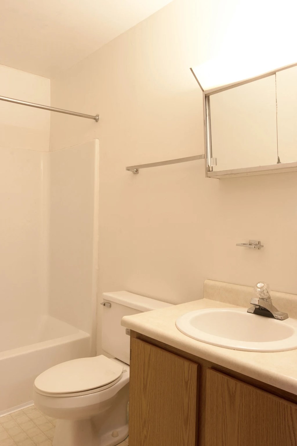 A white toilet sits next to a white sink in a small bathroom.