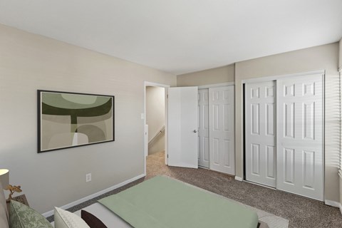 a bedroom with white closets and a green bed and a door to a hallway at Merrick Place, Lexington, Kentucky