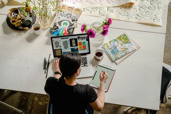 Woman sitting at a desk with a laptop and tablet at Indian Lookout, West Carrollton, OH