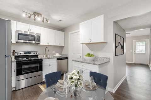 A modern kitchen with a dining table set for two.
