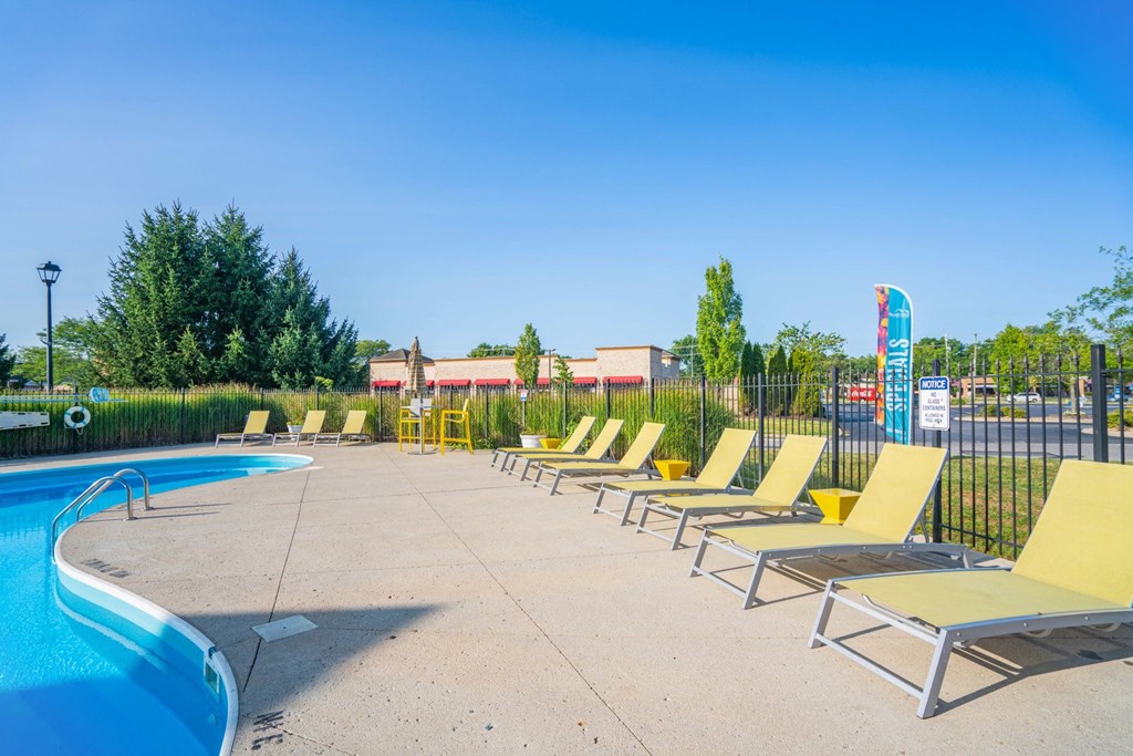 a row of lounge chairs next to a swimming pool at Traditions at Slate Ridge, Reynoldsburg