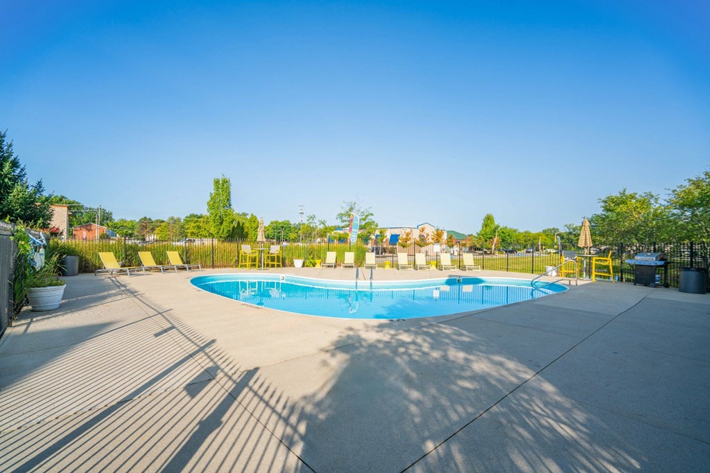 a swimming pool with chairs around it on a sunny day at Traditions at Slate Ridge, Ohio