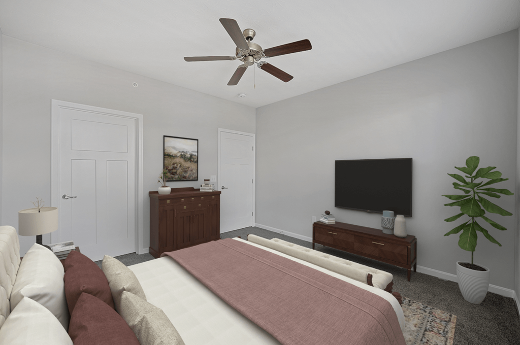 a bedroom with a large bed and a ceiling fan at Monmouth Row Apartments, Newport, KY